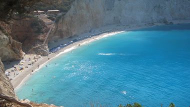 Vista dall'alto della scintillante Spiaggia di Porto Katsiki a Lefkada, con acque cristalline e una stretta fascia di spiaggia bianca incastonata tra le scogliere.