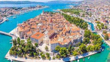 Trogir in Dalmazia - Croazia, Vista aerea panoramica della città storica di Trogir in Croazia, patrimonio dell'UNESCO, con le sue antiche costruzioni in pietra, il campanile che svetta, circondata da acque azzurre e ormeggi pieni di barche a vela, con una vivace atmosfera mediterranea.