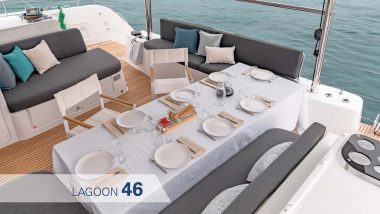 Salotto esterno Catamarano Lagoon 46 - elegante area pranzo esterna pronta per un pasto all'aperto. La tavola è apparecchiata con eleganza, completa di tovaglia, stoviglie bianche e un vassoio di antipasti, il tutto immerso in un'atmosfera serena con vista sul mare tranquillo.